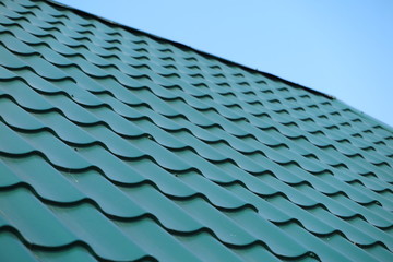 Modern metal tile roofing against a blue sky