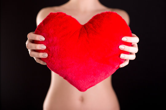 Closeup image of female hands holding red heart