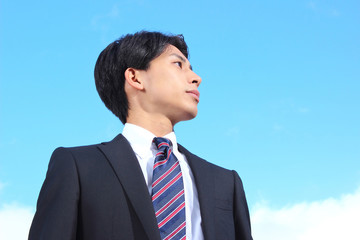 A businessman looking up at the sky