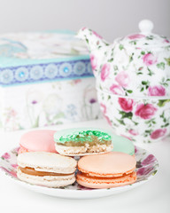 Obraz na płótnie Canvas French macarons with tea set on the background