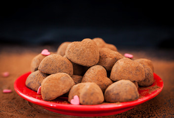 Heart shaped chocolate truffles on red plate