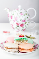 Macarons against tea set on the background