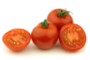 fresh tomatoes and a cut one on a white background