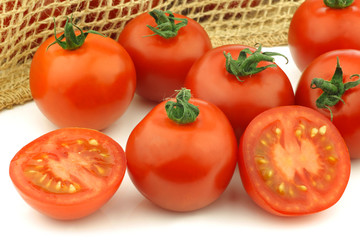 fresh tomatoes and a cut one on a white background