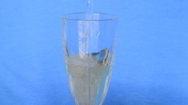 Glass Filled with Champagne in Slow Motion