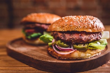Fresh burger on wooden table. - obrazy, fototapety, plakaty