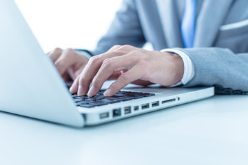 Closeup of businessman hands typing on laptop computer