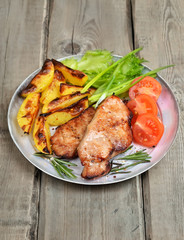 Roasted pork chop with vegetables on rustic table