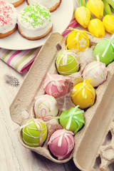 Easter with yellow tulips, colorful eggs and traditional cakes