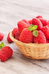 Raspberries in a cute basket vertical composition