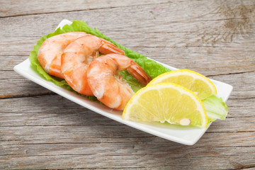 Cooked shrimps with lemon and salad leaves