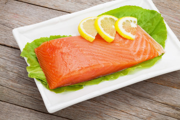 Fresh salmon fish with lemon and salad leaves