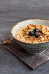 Oatmeal breakfast served with sliced bananas and berries
