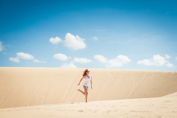 Young woman running on dunes