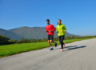 Young couple jogging in park at morning. Health and fitness.