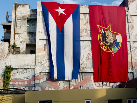 Immenses drapeaux cubains étendus sur un mur.