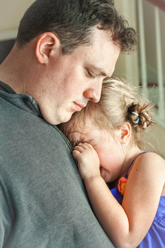 sad father comforting his crying daughter. Great parenting image