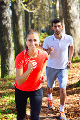 Fototapeta premium Young couple jogging in park at morning. Health and fitness.