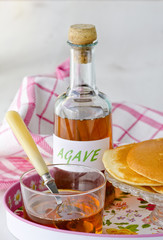 Agave syrup and a plate of pancakes.
