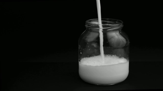 Milk pour into a glass jar
