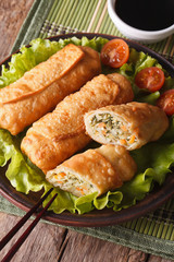 Cut spring rolls fried with sauce closeup vertical, top view