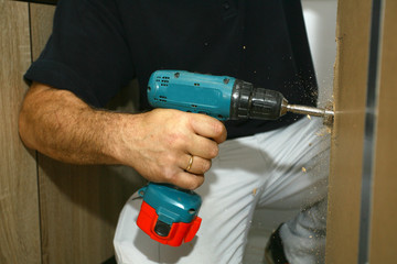 the master working with drill over new kitchen cases