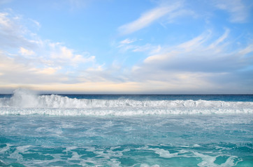 White foamy waves and gradually darkening color of sea water wit