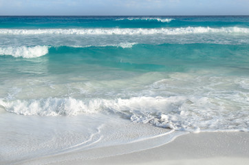 White foamy waves and gradually darkening color of sea water wit