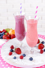 Delicious berry cocktails on table on brick wall background