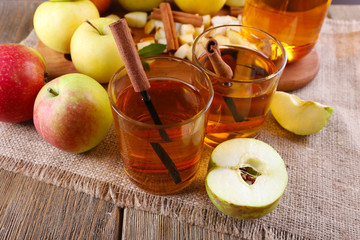 still life with apple cider and fresh apples on wooden table