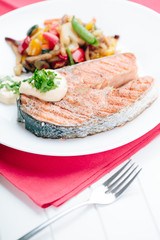 Grilled Salmon with Fresh vegetables on red background