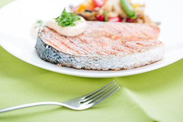 Grilled Salmon with Fresh vegetables on green background