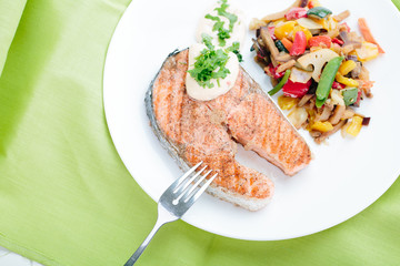 Grilled Salmon with Fresh vegetables on green background