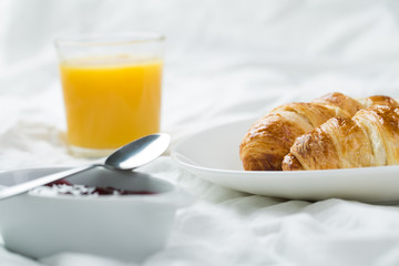 delicious breakfast with croissants in bed
