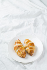 delicious breakfast with croissants in bed