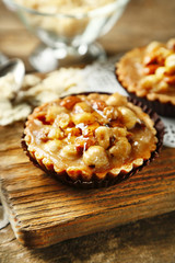 Mini cakes with nuts on wooden background