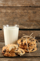 Tasty cookies and glass of milk on rustic wooden background