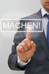 Mann drückt MACHEN-Knopf