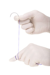Surgical needle in the hands of the surgeon
