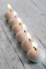 Burning candles on wooden table close-up