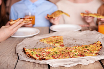 Friends hands taking slices of pizza