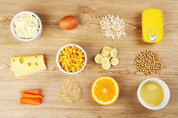 Various food products containing vitamins on wooden background