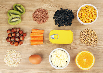 Various food products containing vitamins on wooden background