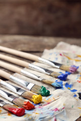 Obraz premium Brushes with colorful paints on dirty cloth