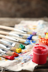 Brushes with colorful paints on dirty cloth