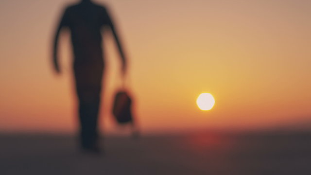 Man holding arms up in praise against a background of sunrise