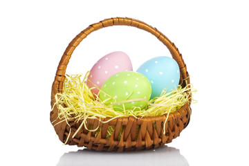 Fototapeta na wymiar Ester Eggs in basket with hay