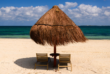Umbrella and two chairs on sand beach