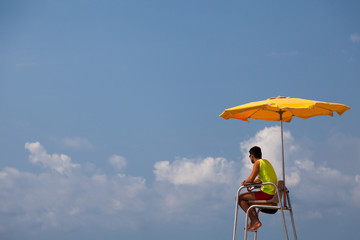 Lifeguard under orange umbrella
