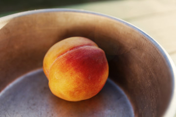 Peach in a metal bowl